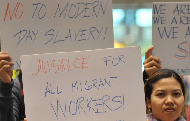 Foreign migrant workers hold placards during a demonstration in the Central lobby of Taipei Train Station on February 9, 2014. (Photo: AFP-Mandy Cheng)