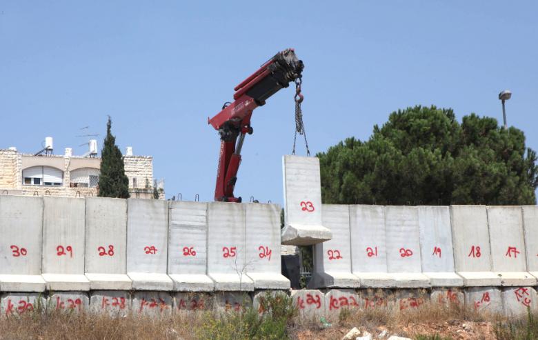 A photo taken on August 15, 2010, shows a crane lifting numbered two-meter-high concrete blocks erected nine years ago in Israeli annexed east Jerusalem close to the Palestinian village of Beit Jala. (Photo: AFP - Ali Tibbon)
