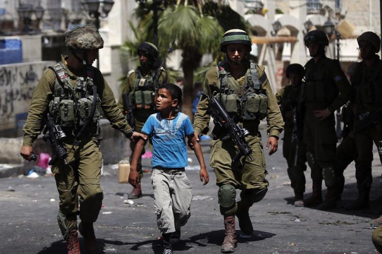 Israeli soldiers arrest a young Palestinian boy following clashes in the center of the West Bank town of Hebron, on June 20, 2014. (Photo: Thomas Coex / AFP)